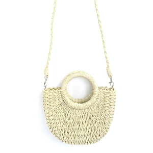 Detail of hand-woven straw crossbody bag with round handle and detachable shoulder strap