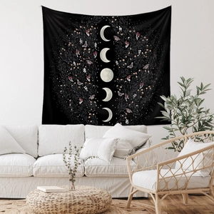 Detail of bohemian moon phase tapestry with moth and floral patterns in a cozy room