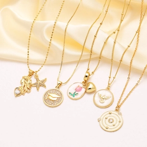 Collection of gold zircon necklaces with shell heart and flower pendants on silk