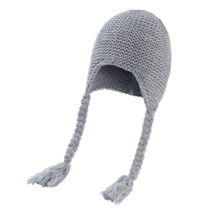 Detail of grey knitted baby hat showing the warm texture and long braided tassels