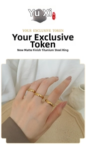 Close-up of stacked polished 18K gold titanium steel minimalist rings on finger