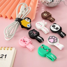 Close-up of colorful cartoon animal silicone cable organizers on a desk with charging cords