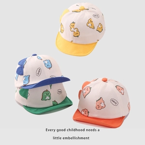 Detailed close-up of soft cotton baby baseball caps with cute dinosaur prints and 3D scales