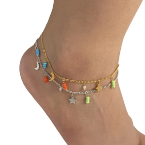 Double-layered gold and silver anklet with moon and star charms on model ankle