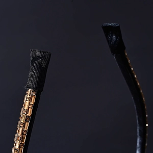 Detail of the black fabric-wrapped end and amber crystal rhinestones on a thin headband