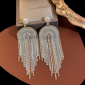 Elegant gold drop earrings with white pearls and sparkling diamond-studded tassels on leather