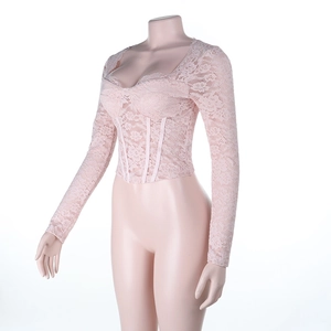 Close-up of pink long sleeve lace top with corset-style stitching and floral texture