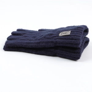 Close-up of navy blue knitted fingerless gloves with a deer logo patch on the wrist