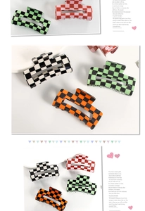 Detail view of colorful checkerboard hair claws in black, green, orange and red patterns
