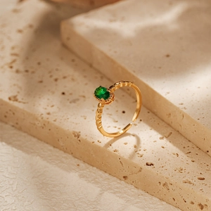 Detailed macro view of 18K gold plated adjustable ring with oval green gemstone
