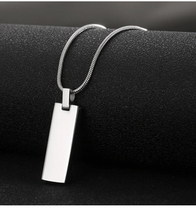 Polished silver stainless steel bar pendant with matching snake chain on textured background
