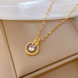 Collana di lusso in titanio dorato con pendente tondo in zircone su scatola beige