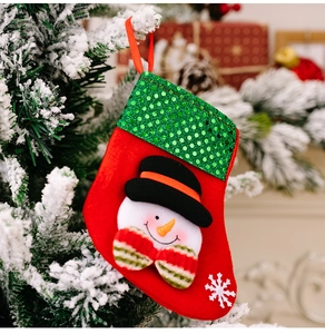 Detail of sequined Christmas stocking with snowman embroidery hanging on a tree