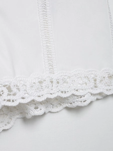 Gros plan sur les coutures en dentelle au crochet et la broderie ajourée blanche