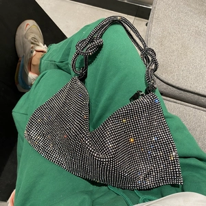 Detailed close-up of sparkling rhinestone handbag with iconic knot handle design