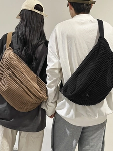 Minimalist corduroy crossbody bag in brown and black shown on a male model outdoors