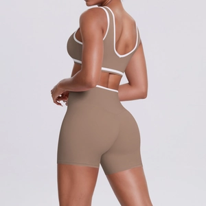 Detail of high-stretch brown yoga set with white trim showing racerback and high waist fit