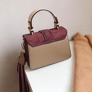 Detailed view of bicolor crossbody bag with brown leather and dark red suede flap