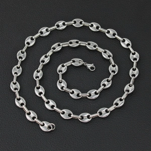 Polished silver stainless steel coffee bean chain necklace on textured black background