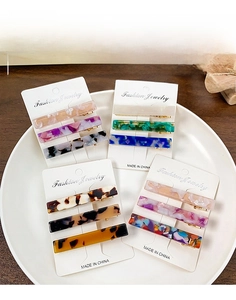 Close-up of elegant acetate hair clips in tortoiseshell and marble patterns on display