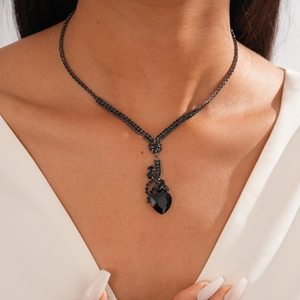 Gros plan d'un collier avec pendentif cœur noir et strass sur un mannequin féminin