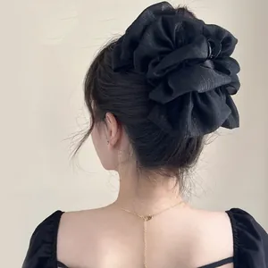 Detailed back view of a large black mesh bow hair claw clip in an elegant updo hairstyle