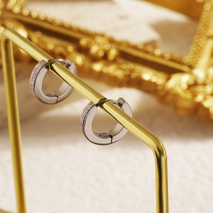 Minimalist silver stainless steel hoop earrings with textured frosted finish on gold stand