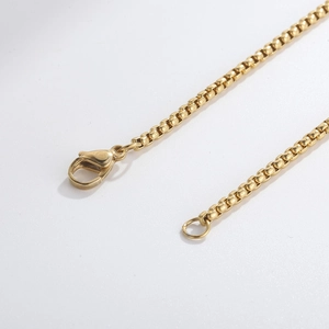 Macro shot of gold box chain necklace details with a secure lobster clasp closure