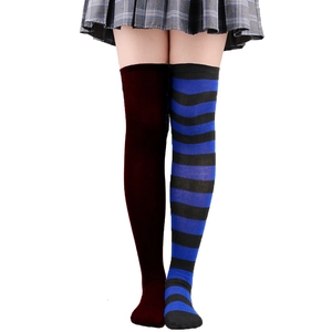 Détail de chaussettes montantes asymétriques en rouge foncé et rayures bleu-noir