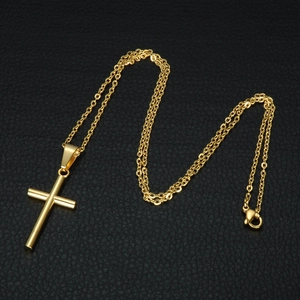 Detailed view of polished gold cross pendant with smooth cylinder design on black leather