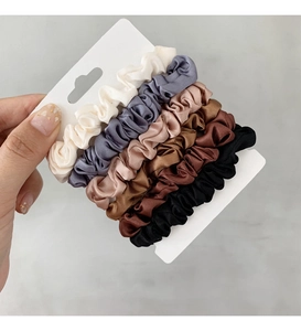 Dettaglio di un set di 6 elastici in raso francese in colori neutri su cartoncino