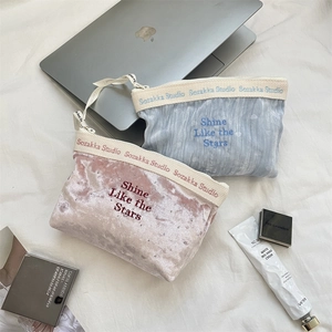 Dettaglio di borse per cosmetici in velluto rosa e blu con ricamo Shine Like the Stars e paillettes