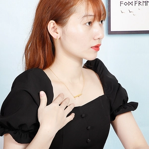 Chic gold bar necklace and matching stud earrings set worn by a female model