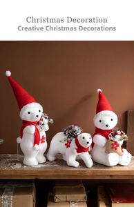 Detailed view of three white Christmas polar bears wearing red hats and scarves on a wooden shelf