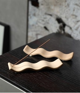 Détail d'un porte-encens minimaliste en céramique en forme de vague avec bâton d'encens