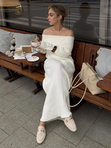 Close-up of the elegant rib-knit texture on a cream white off-shoulder maxi dress