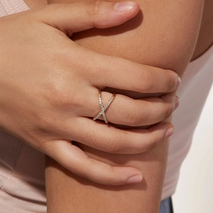 Anello incrociato dorato da donna con micro-pavé di zirconi bianchi indossato dalla modella