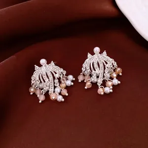 Luxurious silver tassel earrings with pearls and crystals on dark velvet backdrop