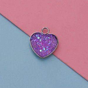 Macro shot of 13mm heart-shaped stainless steel pendant with purple glitter inlay