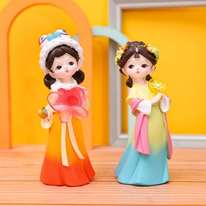 Detailed view of two cute traditional Chinese dolls with butterfly and fan accessories