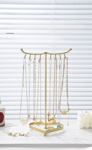 Detail of golden iron jewelry rack with heart base showing necklace and earring hooks