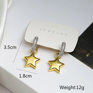 Asymmetric gold star and moon earrings with dimensions and weight detail on jewelry card