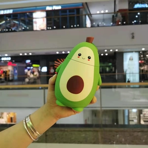 Detail view of a cute green avocado-shaped double-layer glass bottle with a cartoon face