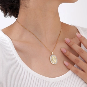 Close-up of golden necklace with oval Virgin Mary pendant and zircon stones