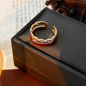 Detail of a vintage double-layer ring with gold chain and red enamel finish on leather box