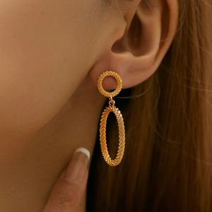Detail of 18K gold double hoop earrings featuring textured matte frosted finish on skin