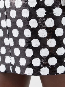 Detailed close-up of premium black and white sequin polka dot fabric with shimmering texture