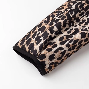Detailed close-up of quilted leopard print jacket cuffs with black trimmed edges