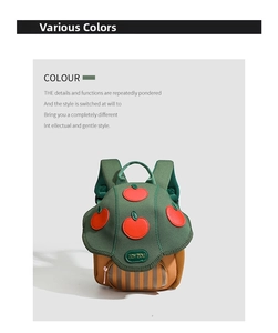 Detail of mushroom-shaped toddler backpack in dark green with red apple patch decoration