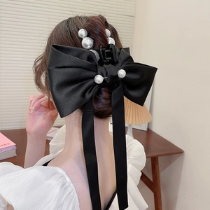 Pince à cheveux noeud en satin noir ornée de perles blanches vue de l'arrière